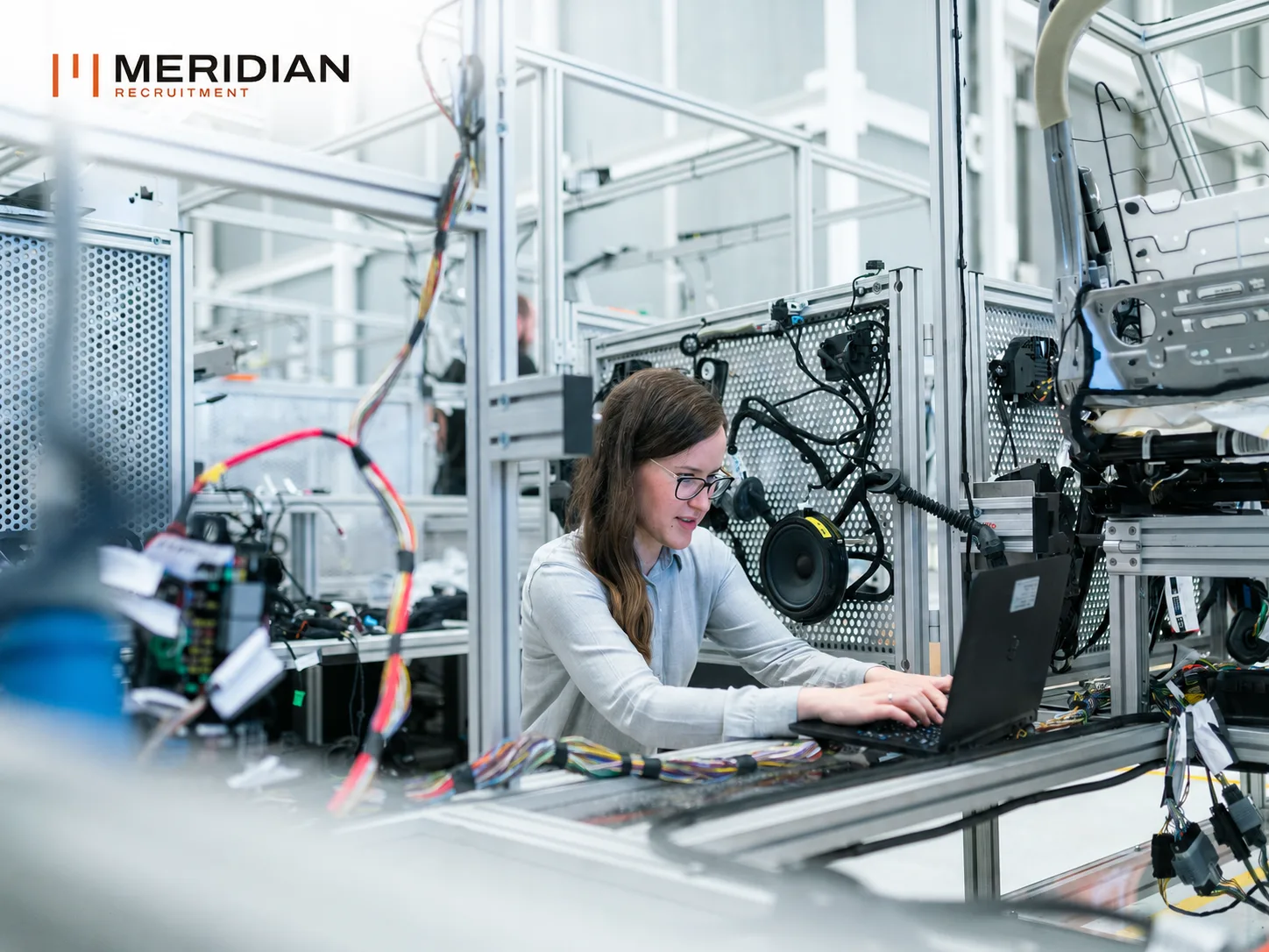 Engineer working at a laptop on a hardware test bench